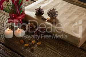 High angle view of illuminated candles with pine cones and gift box