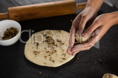 Woman rolling a dough ball in her hand