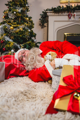 Santa claus sleeping on shrug with teddy bear