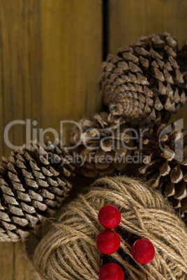 Directly above shot of pine cones with thread spool with push pin