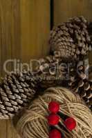 Directly above shot of pine cones with thread spool with push pin