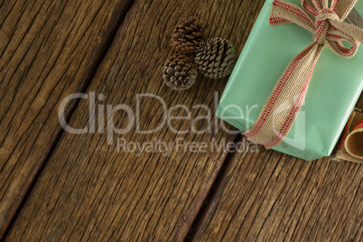 Pine cones and wrapped gift box on wooden table