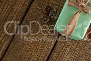 Pine cones and wrapped gift box on wooden table