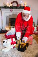 Santa claus arranging gifts in living room at home