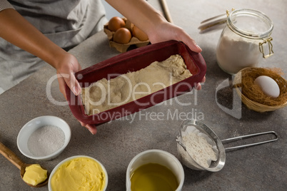 Woman preparing dough surrounded with various ingredients