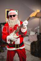 Smiling santa claus playing a guitar