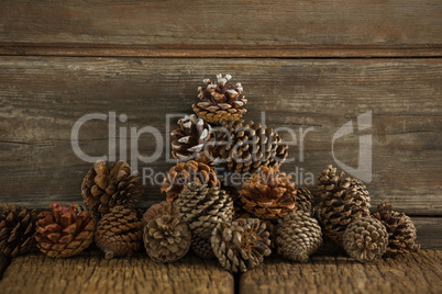 Pine cones against wooden plank