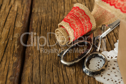 Ribbon and scissors on wooden plank