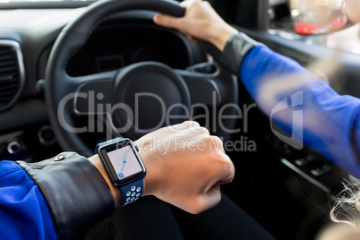 High angle view of woman wearing smart watch in car
