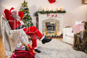 Santa claus relaxing on sofa in living room at home
