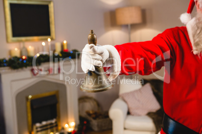 Santa claus ringing a bell at home during christmas time