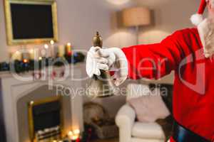 Santa claus ringing a bell at home during christmas time