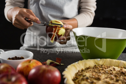 Woman pealing off apple skin