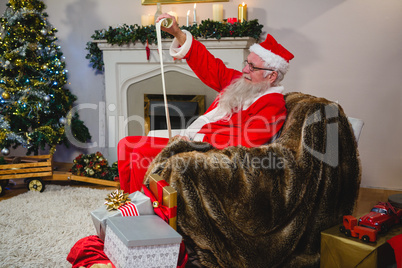 Santa Claus reading scroll in living room