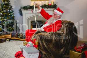 Santa Claus reading scroll in living room