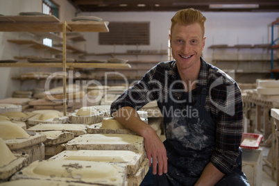 Male potter smiling in pottery workshop