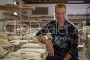 Male potter smiling in pottery workshop