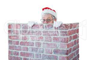 Santa claus hiding behind a chimney