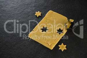 Raw cookie dough with star shaped cookie cutter