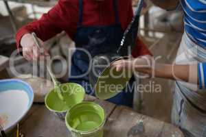 Female potter and boy painting bowl