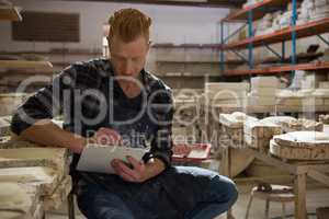 Male potter writing on a clipboard