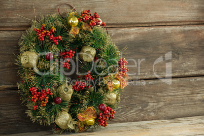 Christmas wreath against wooden surface