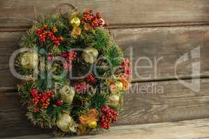 Christmas wreath against wooden surface