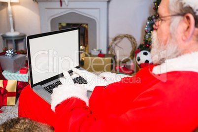 Santa claus sitting and using laptop