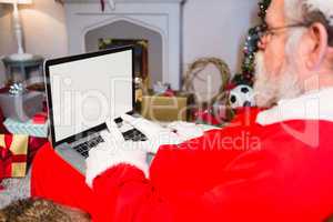 Santa claus sitting and using laptop