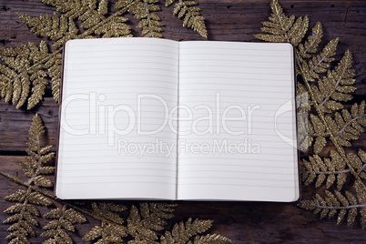 Open book and christmas decoration on wooden plank