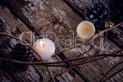 Lit candles and christmas decoration on wooden plank