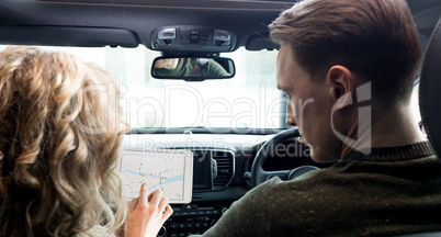 Couple using tablet computer in car
