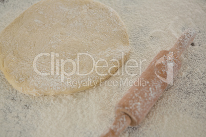 Flattened dough sprinkled with flour on a wooden table