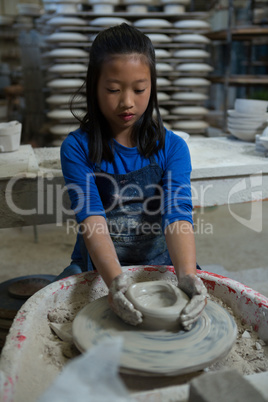 Attentive girl molding a clay