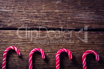 Pink candy canes arranged on wooden plank