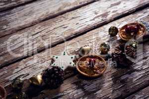 Cookies and christmas decoration arranged on wooden plank