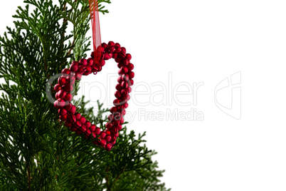 Heart shape christmas decoration hanging on christmas tree