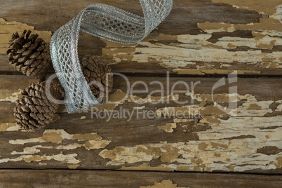 Pine cones with silver ribbon on wooden table