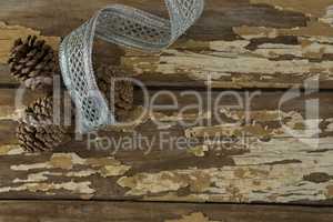 Pine cones with silver ribbon on wooden table