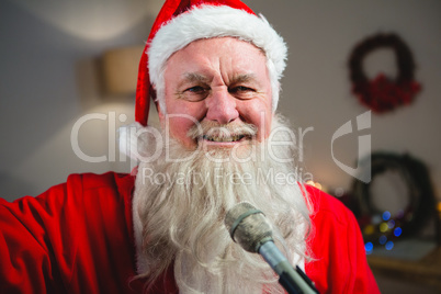 Smiling of santa claus singing a christmas songs at home