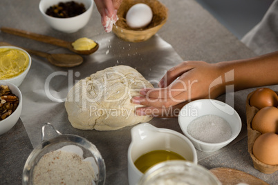 Woman preparing dough surrounded with various ingredients