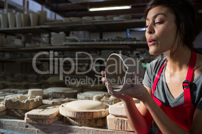 Female potter preparing mug