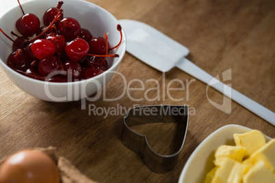 Red cherries in bowl with cookie cutter and cheese