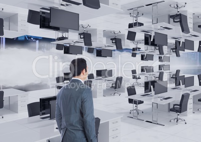 businessman standing in inverted office in the clouds