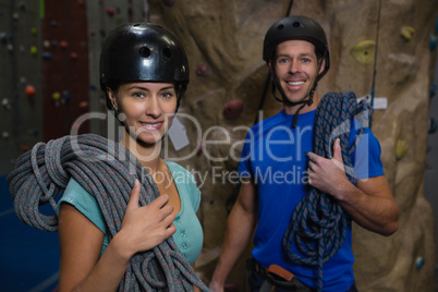 Smiling athletes in sports helmet carrying ropes while standing