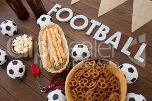 Football text and snacks on wooden table