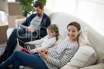 Parents and daughter using electronic devices