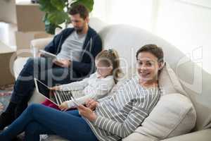Parents and daughter using electronic devices