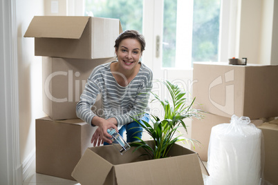 Woman opening cardboard boxes in living room