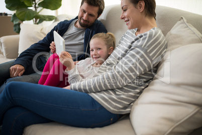 Parents and daughter using digital tablet